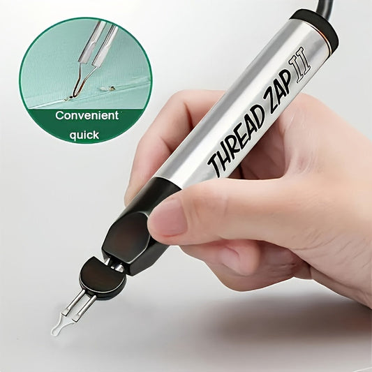 Thread zapper pen held in hand, silver barrel with black grip and metal prongs