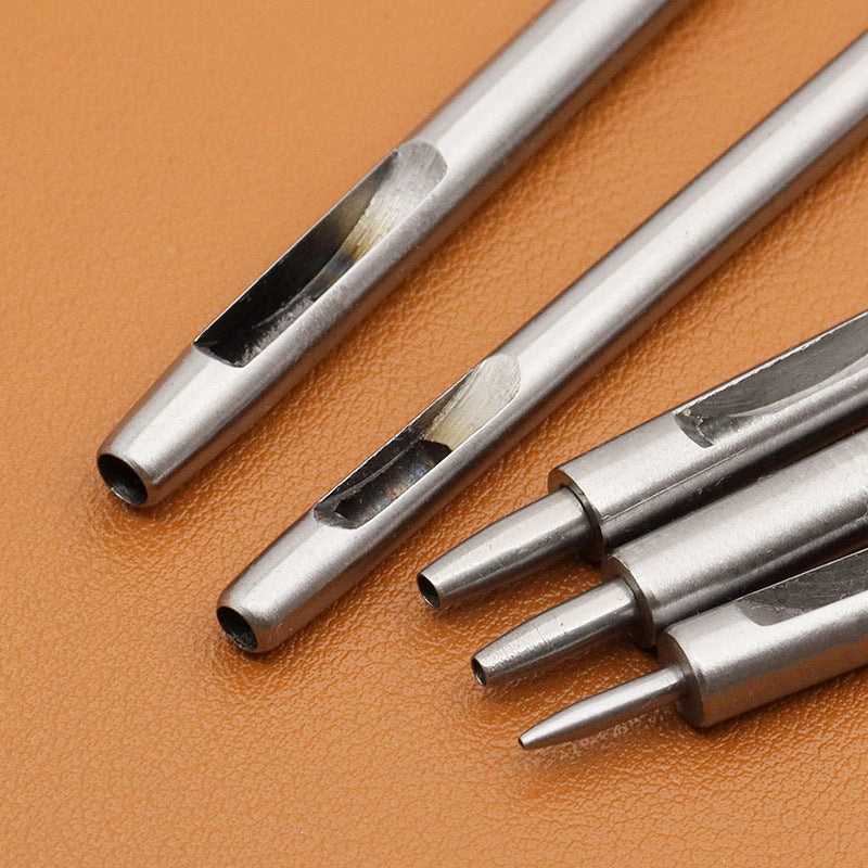 Metal round hole punch tools laid on leather, showing cutting tips