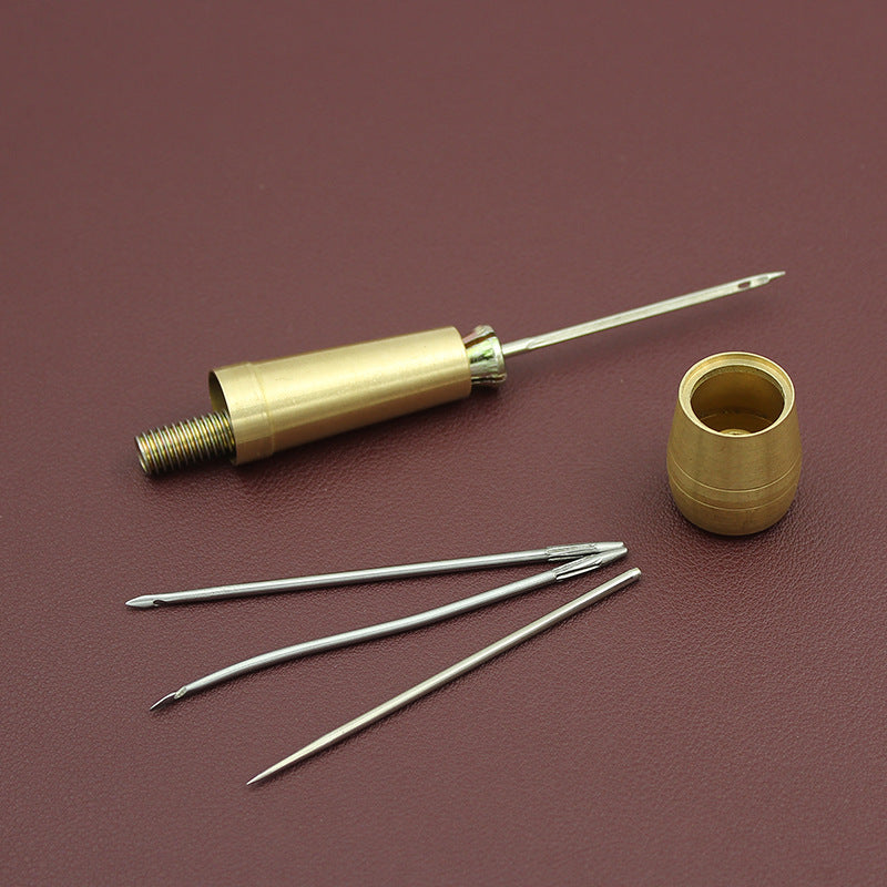 Brass awl handle with pointed bit, plus three metal needles and storage sleeve