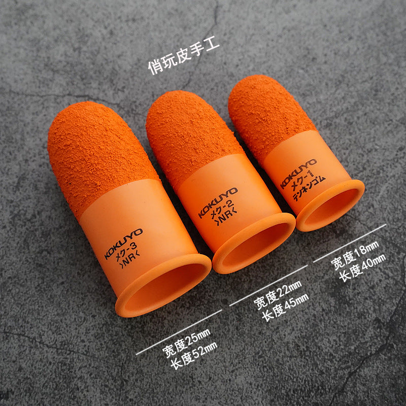 Orange silicone finger guards with textured ends, three pieces on dark surface