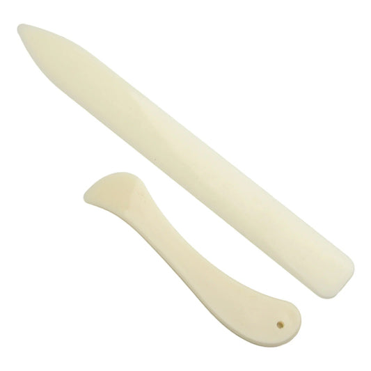 Leather bone folders, cream color, two pieces overlapping at different angles.