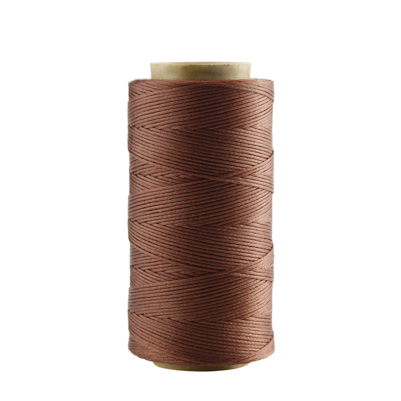 Brown waxed polyester stitching thread spool with visible thread texture