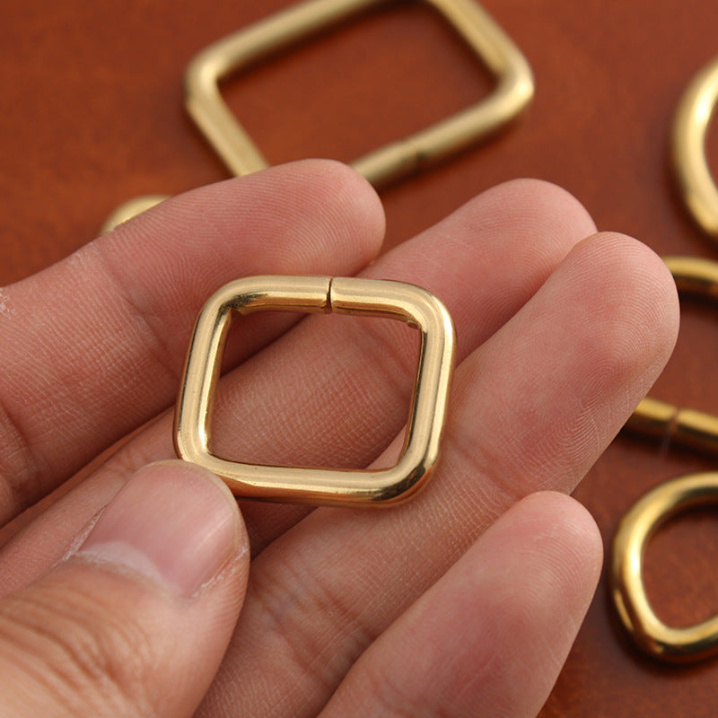 Brass square buckle hardware, rectangular frame with hinged closure, close-up
