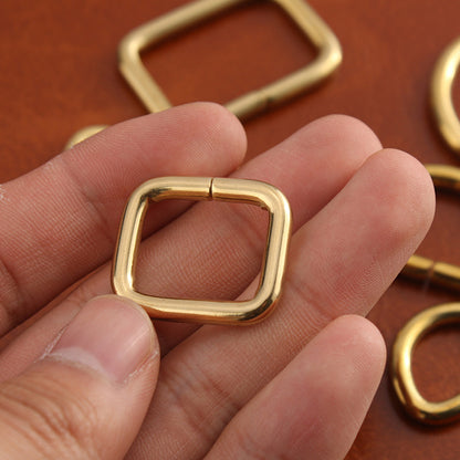 Brass square buckle hardware, rectangular frame with hinged closure, close-up
