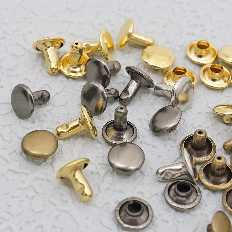 Close-up of double-cap leather rivets in brass, black, and silver tones