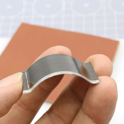 Steel corner rounding die punch held in hand, curved cutting profile with silver edge