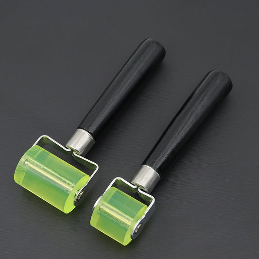 Two silicone glue application rollers with lime green wheels and black handles