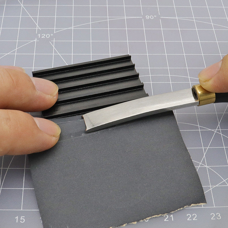 Black beveler & skiving knife sharpener tool clamped under a metal blade