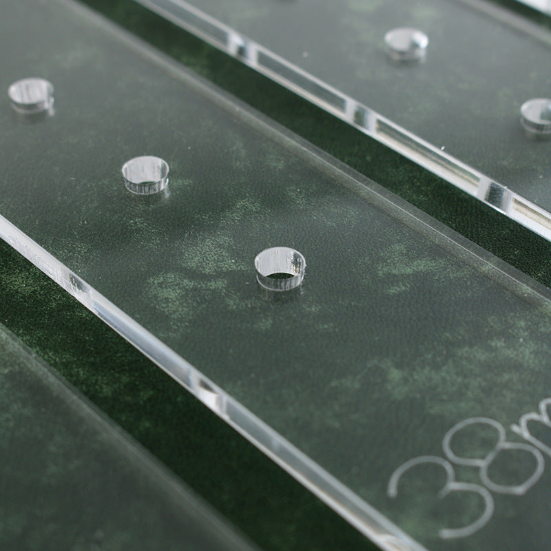 Clear acrylic strip with punched hole guide marks along the length