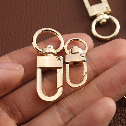 Gold metal swivel hook buckle clasps close-up, with round ring and latch