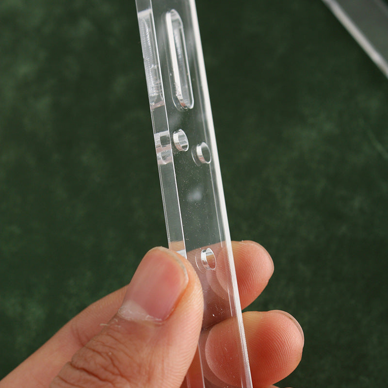 Clear acrylic belt template held by hand, showing long slot and punched holes