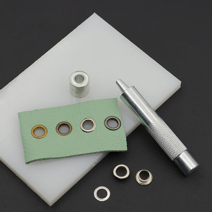 Hand grommet setter tool with base die and metal eyelet rings, included dies shown