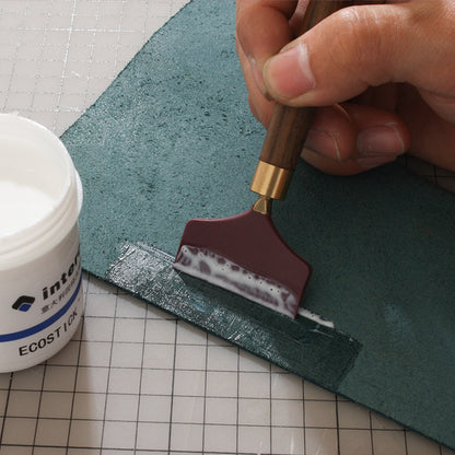 Silicone glue scraper spreader tool with dark brown wood handle and maroon rubber head