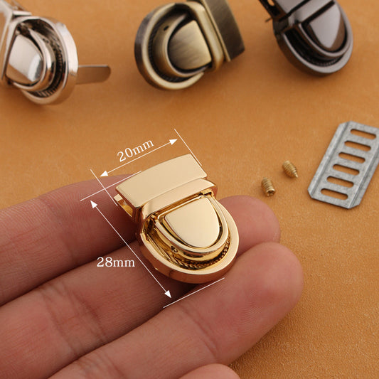Gold metal twist-lock bag buckle with curved latch and size markings 20x28mm
