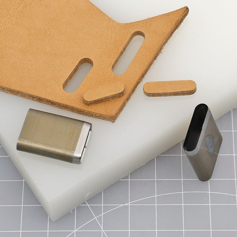 Slot punch die cutter blocks beside a leather piece with two long punch openings