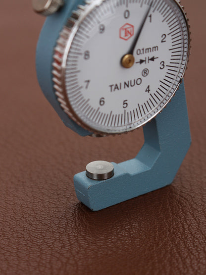 Dial micrometer anvil base with flat contact pad and partial numbered dial