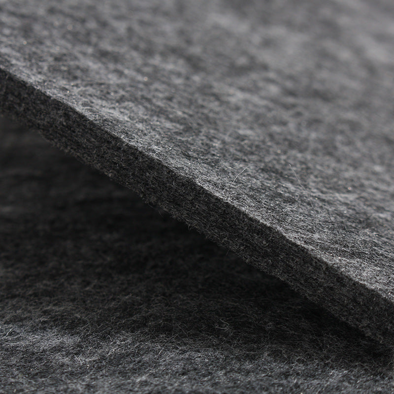 Dark grey felt mat close-up, dense fibrous surface texture