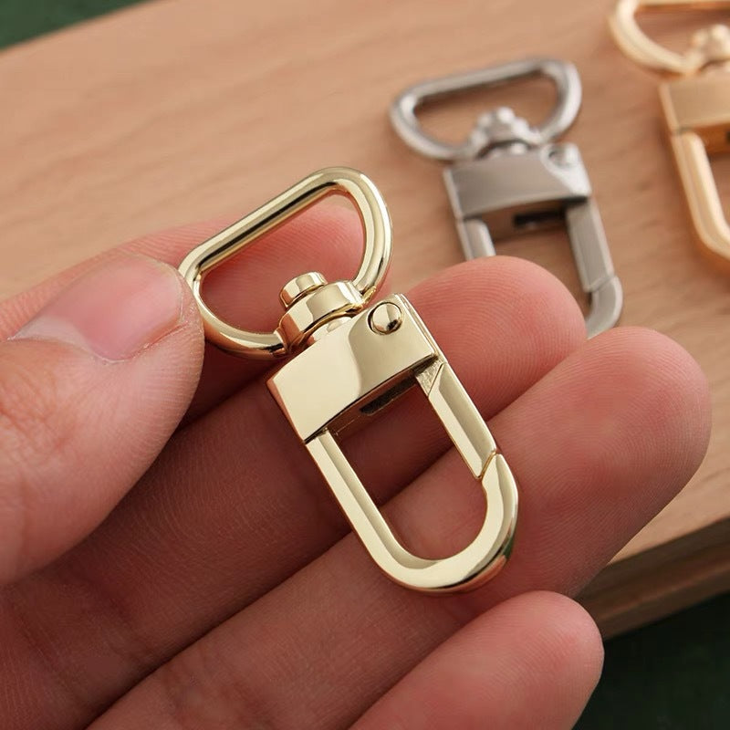 Light gold zinc alloy swivel snap hook with rotating clasp, close-up view.