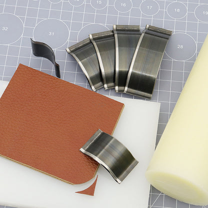 Steel curved corner cutter dies with leather offcuts and cut piece on grid