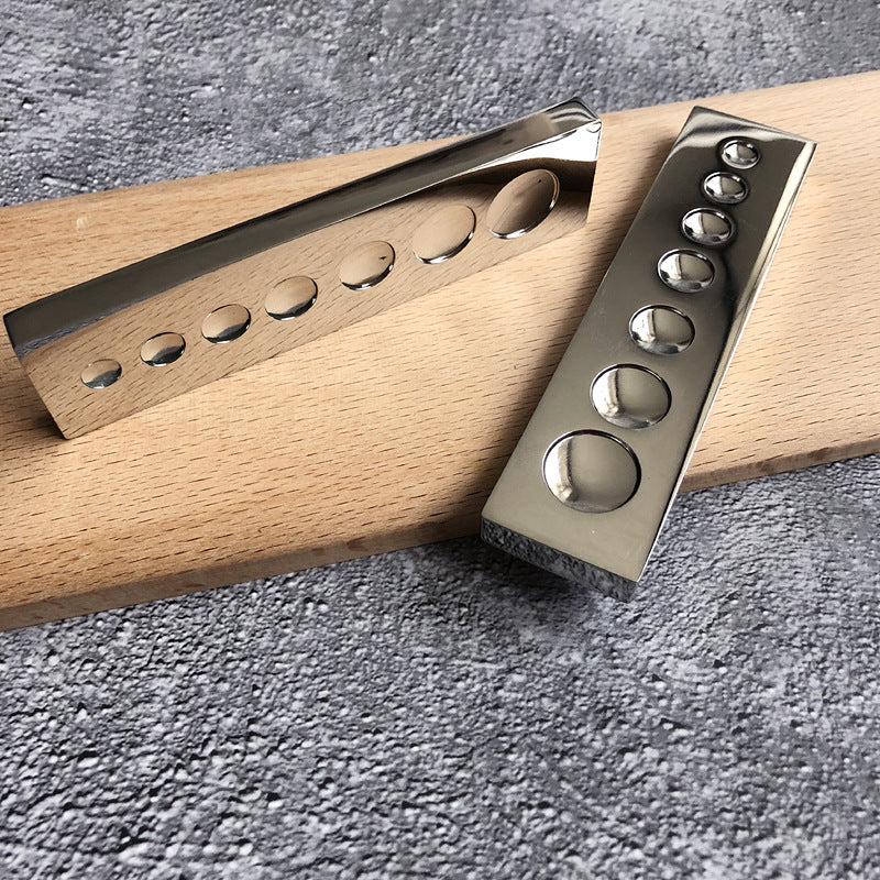 Stainless steel rivet-setting dapping block with concave dimples along metal strip