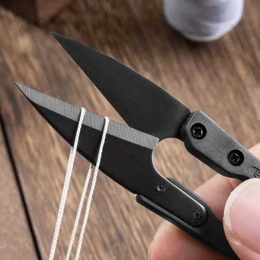 Thread nipper close-up with black handle, metal blades, and finger grip