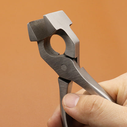 Stainless chrome steel leather craft pliers, close-up of circular die jaw