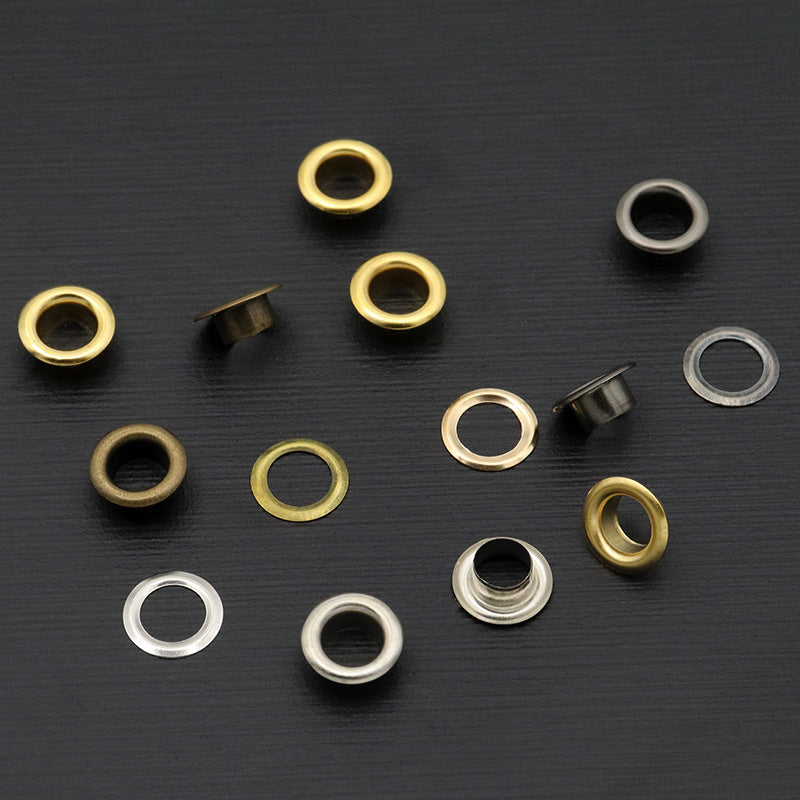 Metal eyelet rings in gold, bronze, silver, and dark finishes, mixed set