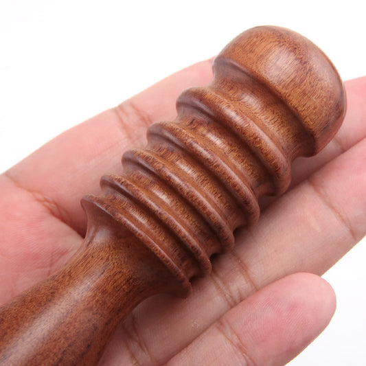 Ribbed wooden leather burnisher held in hand, rounded head