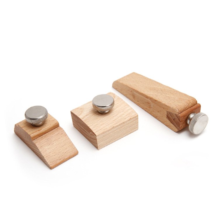 Three wooden blocks with metal knobs on a white background
