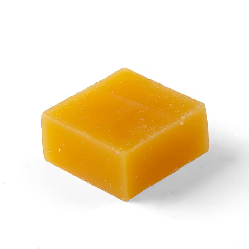Square block of beeswax on a white background