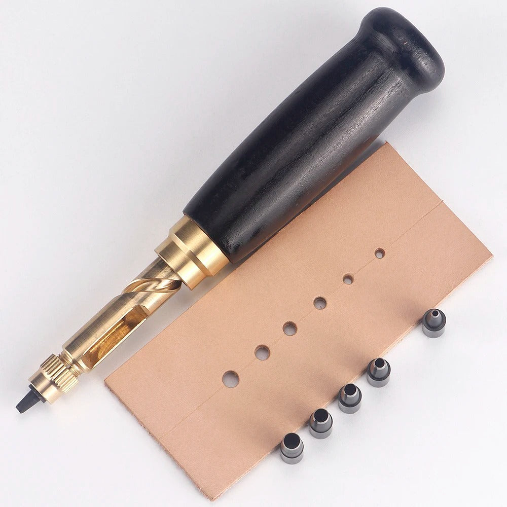 Black-handled rotary leather punch tool with leather sheet and conical heads