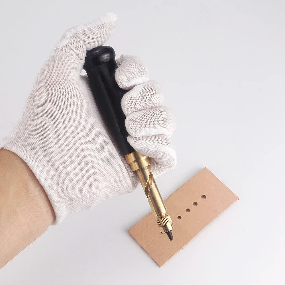 Gloved hand using rotary leather punch tool to create holes in light brown leather
